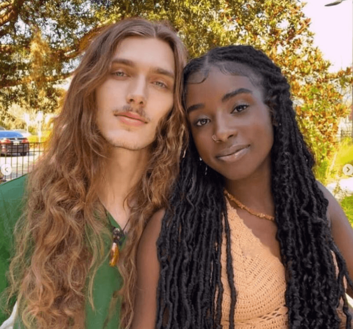 A white boy and a black girl with their heads together