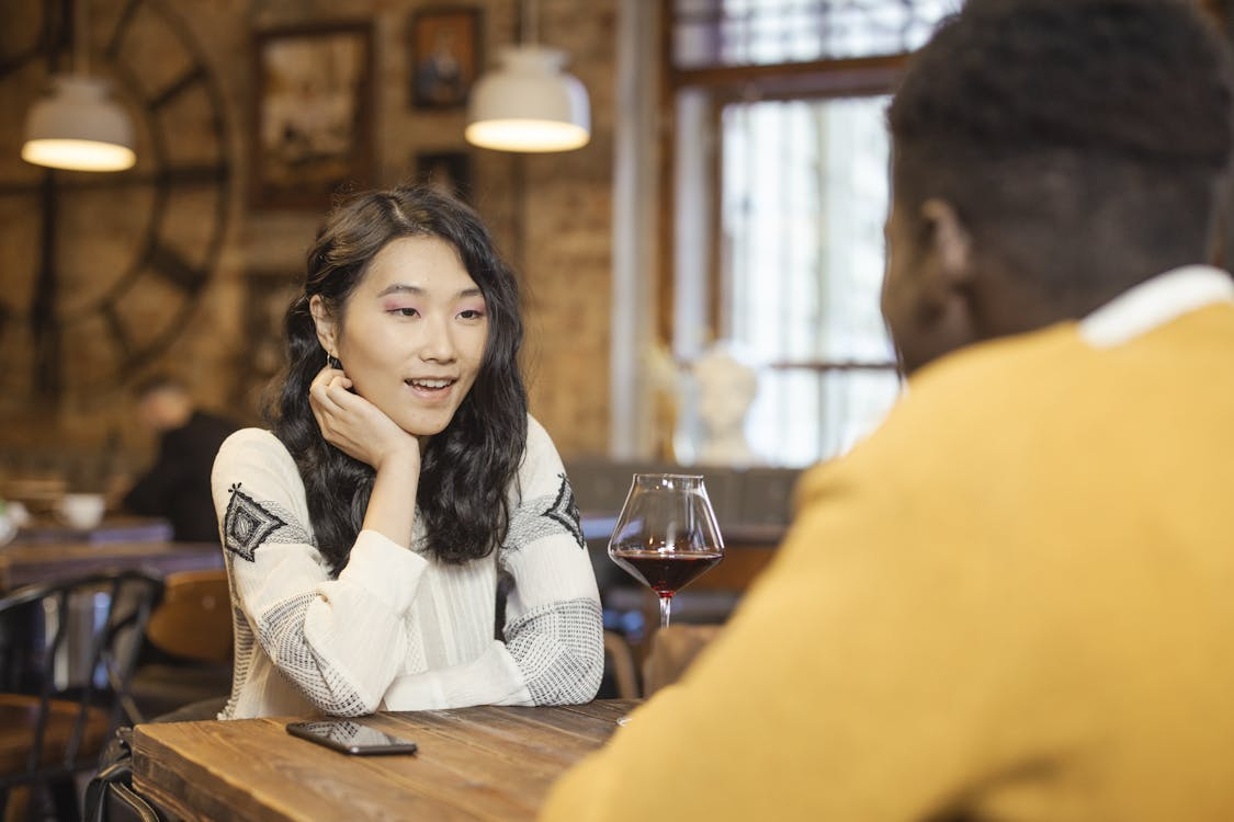 {{https://mixerdates.com/?ch=mixerblog}}Man and woman laughing together on a playful date, building connection through authentic questions.